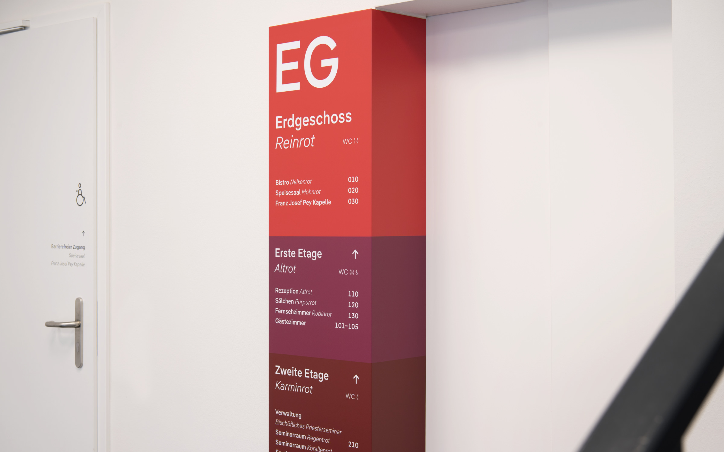 The three floors of the seminary are characterized by different shades of red; the white lettering is set in the geometric-humanistic sans-serif Pangea Text. (© Linda Blatzek)